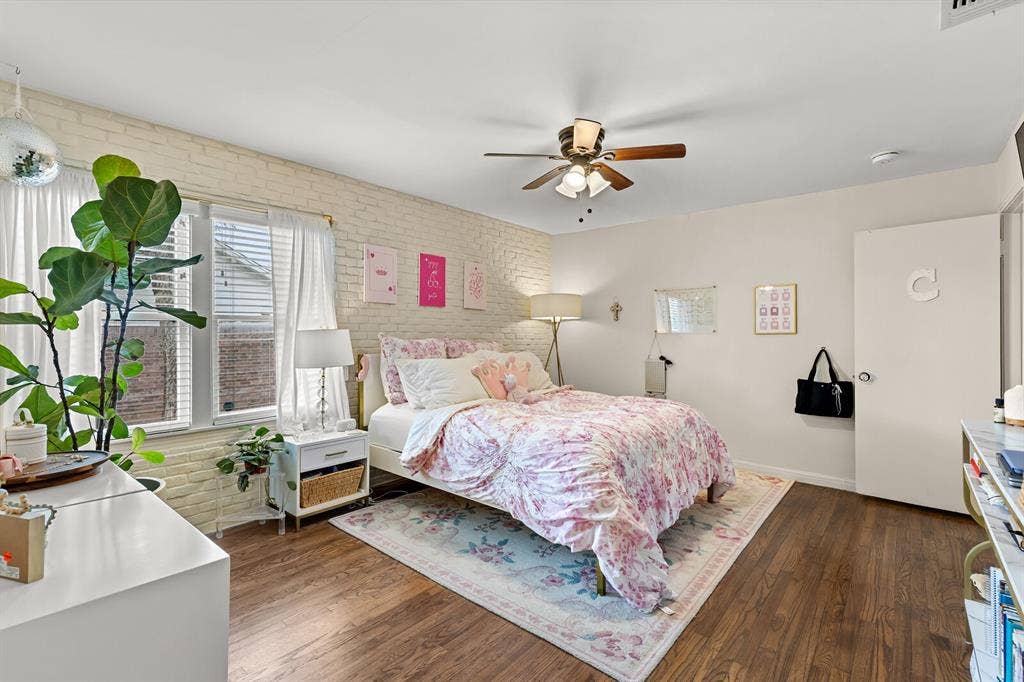 2425 S 2nd Street, Waco, TX 76706 Exposed white brick wall, wood-finish flooring, and a ceiling fan with integrated lighting