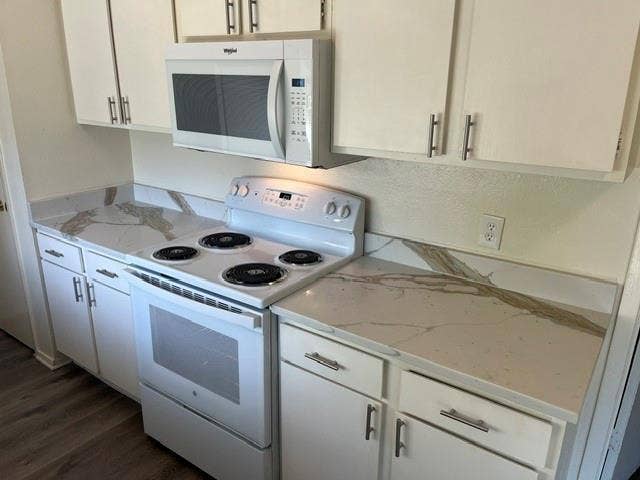1236 Neptune Drive, Cedar Hill, TX 75104 White cabinetry with brushed nickel hardware, stone-patterned countertops, integrated backsplashes, a white electric range, and an over-the-range microwave
