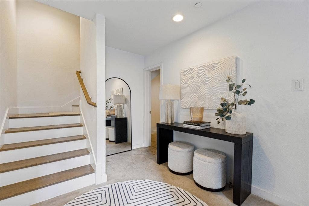 2107 Bennett Avenue, #20, Dallas, TX 75206 Staircase featuring wood-finish treads and white risers, accompanied by a wall-mounted wooden handrail and recessed lighting