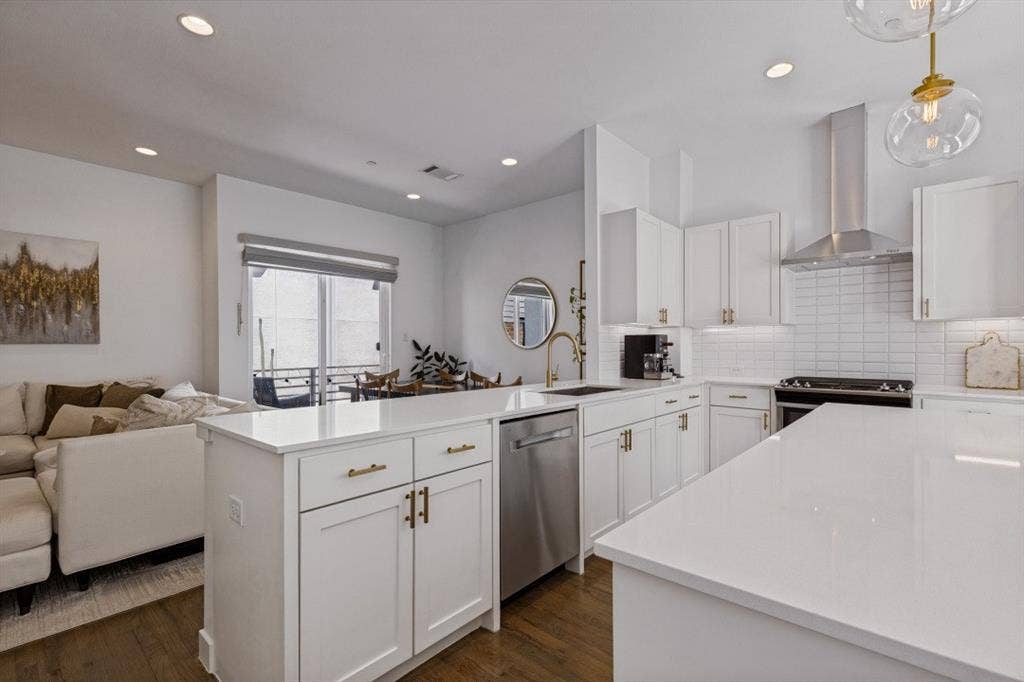 2107 Bennett Avenue, #20, Dallas, TX 75206 Kitchen featuring white shaker-style cabinetry, quartz countertops, a stainless steel range hood, subway tile backsplash, and wood-finish flooring