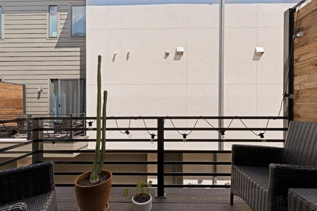 2107 Bennett Avenue, #20, Dallas, TX 75206 Outdoor deck featuring wood-finish decking, horizontal metal railings, and natural wood privacy fencing