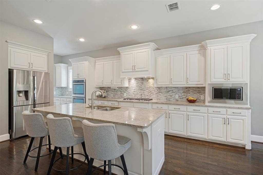 301 Longhorn Drive, McKinney, TX 75071 Chef’s kitchen with a large center island, five burner gas cooktop, double ovens, range hood and butler’s pantry.
