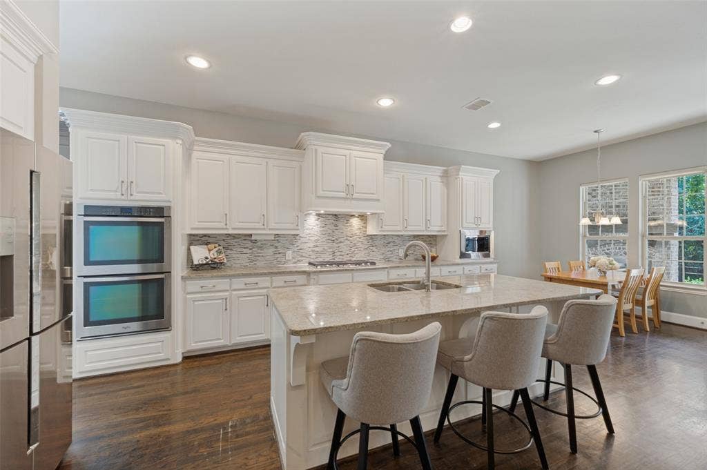 301 Longhorn Drive, McKinney, TX 75071 Chef’s kitchen with a large center island, five burner gas cooktop, double ovens, range hood and butler’s pantry.