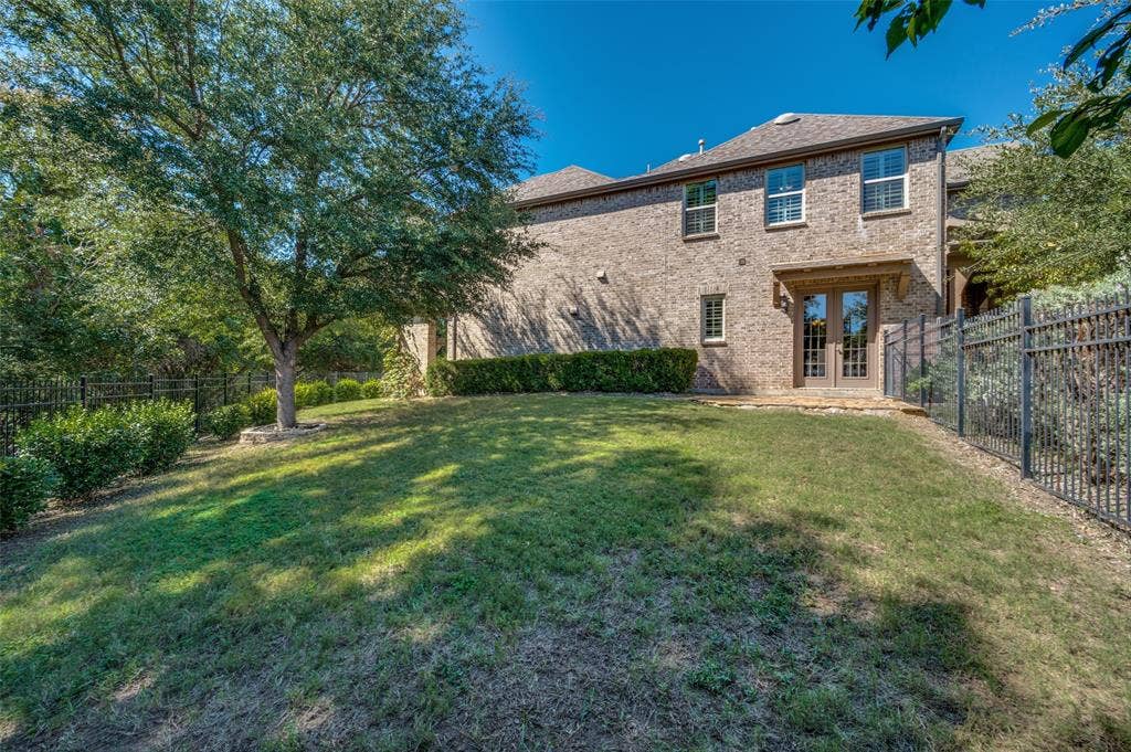 301 Longhorn Drive, McKinney, TX 75071 Covered patio with a wood burning fireplace overlooking the greenbelt and spacious backyard.