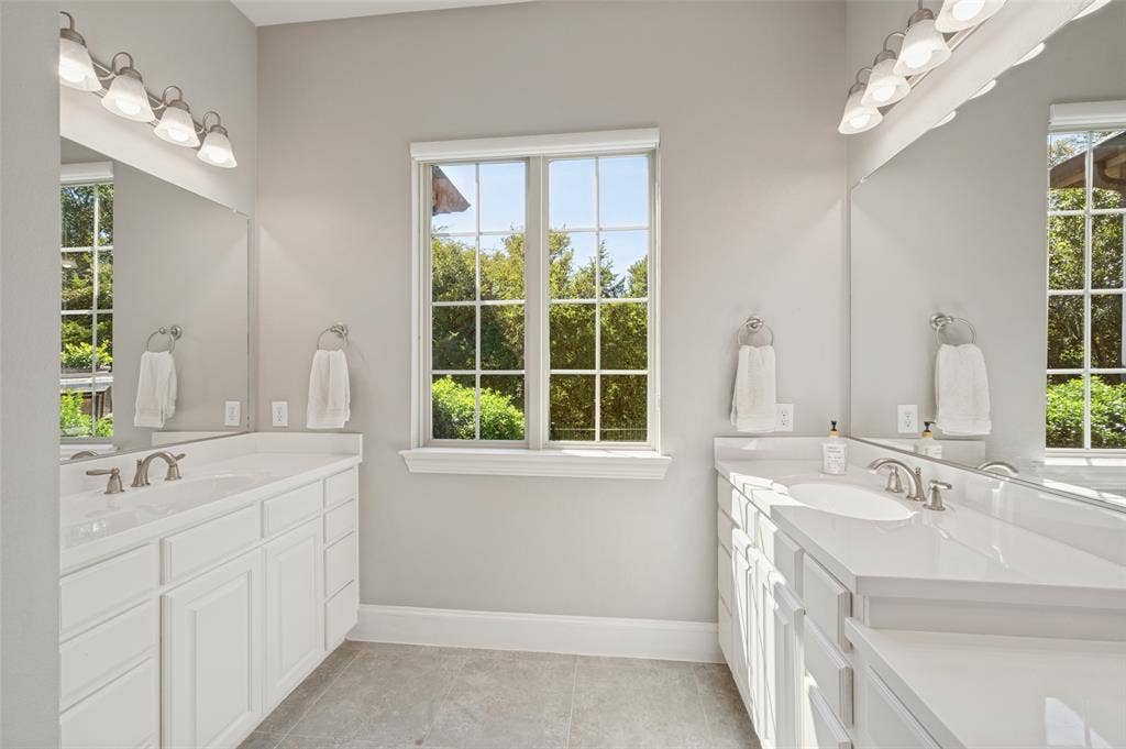301 Longhorn Drive, McKinney, TX 75071 First floor primary suite with generous space and an ensuite bath featuring separate vanities, a soaking tub and separate shower.