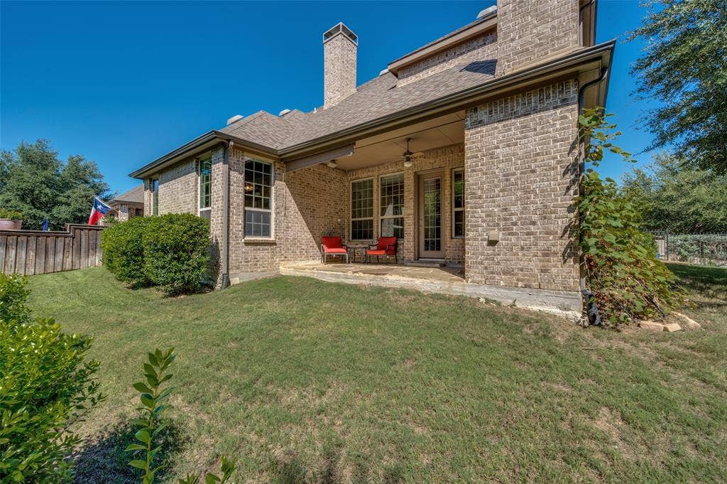 301 Longhorn Drive, McKinney, TX 75071 Covered patio with a wood burning fireplace overlooking the greenbelt and spacious backyard.