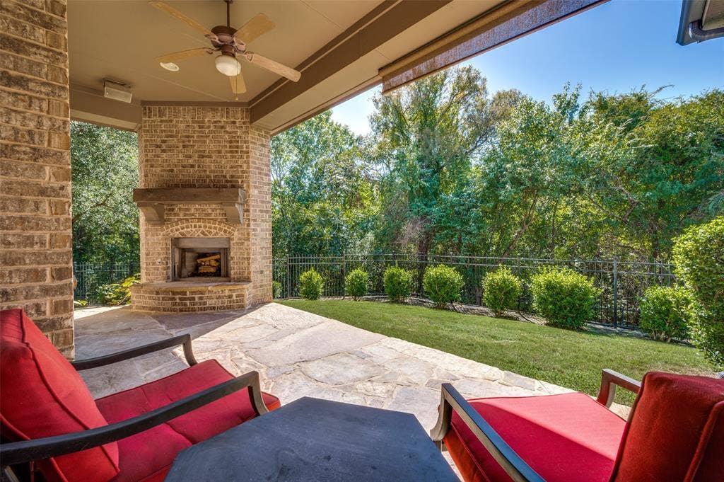 301 Longhorn Drive, McKinney, TX 75071 Covered patio with a wood-burning fireplace overlooking the greenbelt and spacious backyard.