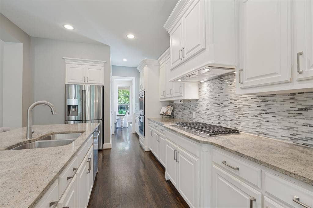 301 Longhorn Drive, McKinney, TX 75071 Chef’s kitchen with a large center island, five burner gas cooktop, double ovens, range hood and butler’s pantry.