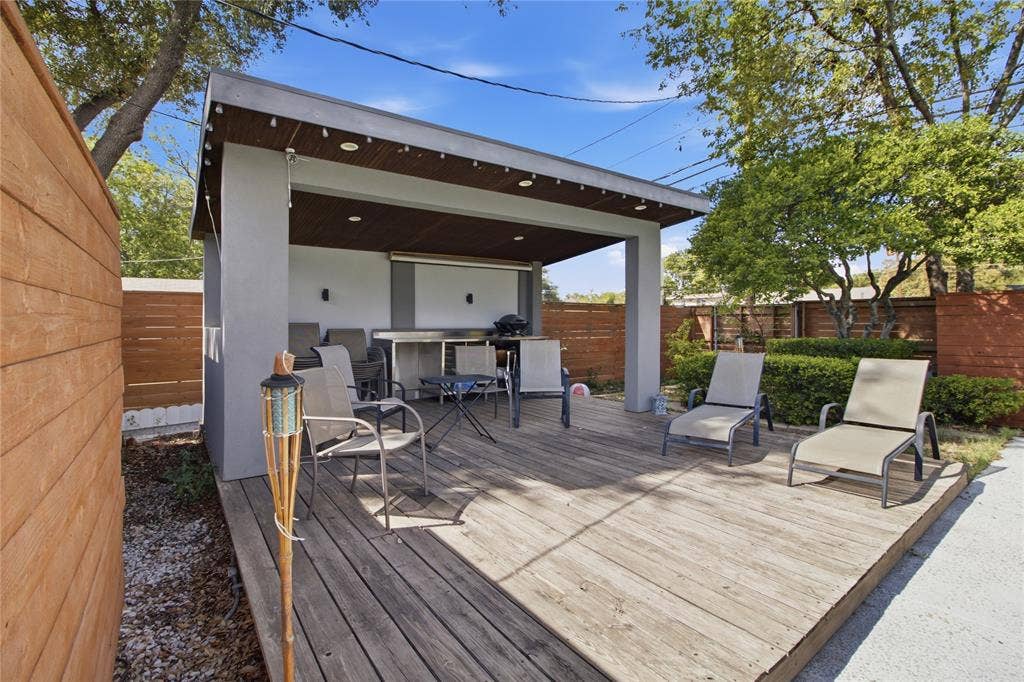 2712 Beechmont Place, Dallas, TX 75228 Take outdoor living to the next level with this spacious poolside cabana and expansive wood deck. The covered gathering area features a rich wood-paneled ceiling, recessed lighting, and decorative string lights that help set the mood for evening gatherings. With room for dining, conversation, and poolside lounging, this versatile space is equally suited for intimate get-togethers or lively celebrations. The adjacent open deck provides additional space to enjoy the sunshine just steps from the pool.
