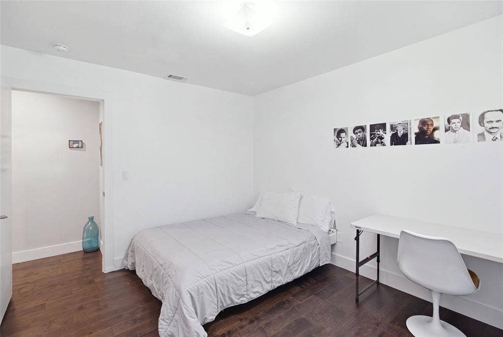 2712 Beechmont Place, Dallas, TX 75228 This secondary bedroom features rich, dark flooring, neutral walls, and space for both sleeping and studying or working. Its simple, versatile layout makes it easy to personalize for a variety of needs.