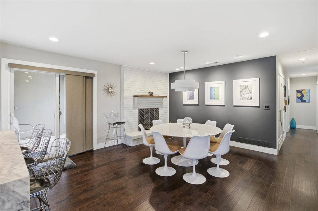 2712 Beechmont Place, Dallas, TX 75228 The dining area combines contemporary style with distinctive architectural character. A contrasting charcoal accent wall, modern pendant lighting, and white-painted brick create an inviting atmosphere, while the open layout provides a natural connection to the kitchen. Sliding glass doors bring in natural light and offer convenient outdoor access, making this a welcoming space for everything from everyday meals to entertaining guests.