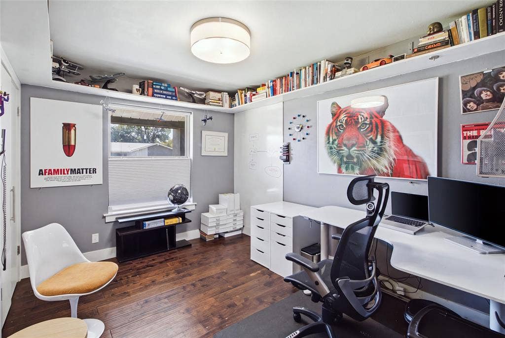 2712 Beechmont Place, Dallas, TX 75228 Currently arranged as a home office, this secondary bedroom demonstrates the home's flexible living spaces. Rich flooring, contemporary lighting, and extensive upper-wall shelving create a distinctive workspace, while a large window brings in natural light. The room can easily serve as a traditional bedroom, study, or creative retreat to suit your needs.