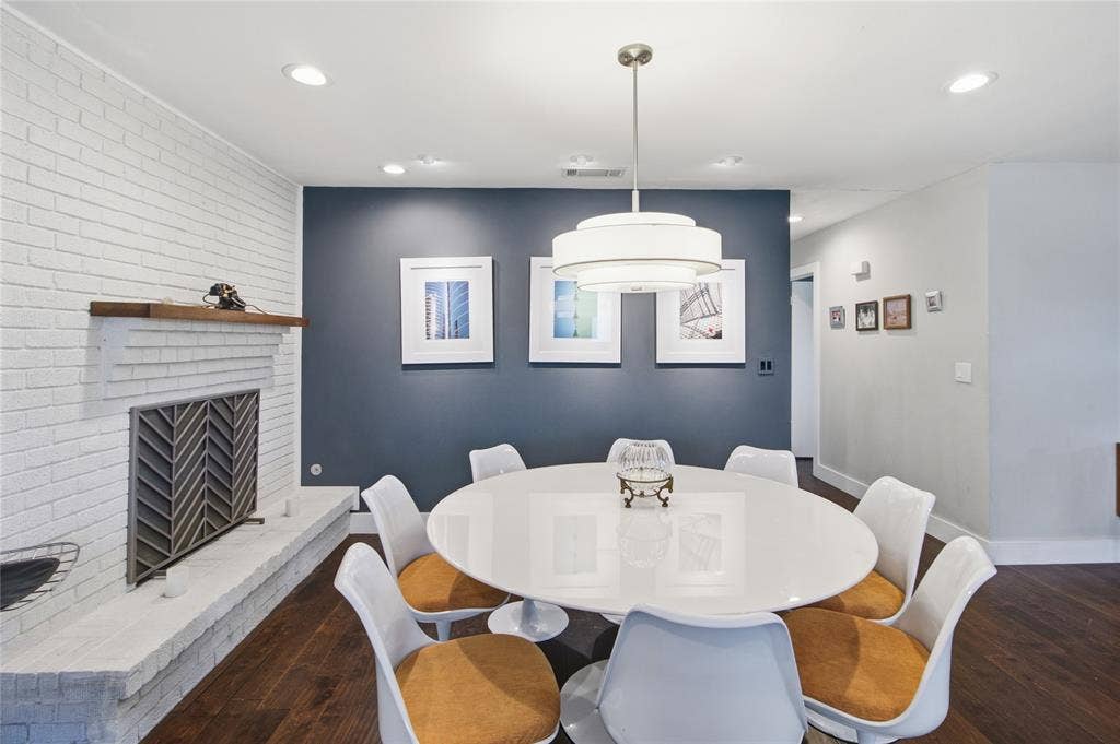 2712 Beechmont Place, Dallas, TX 75228 Imagine gathering around the table for a memorable dinner with the warmth and ambiance of a real wood-burning fire nearby. The fireplace features a convenient gas starter and distinctive geometric-patterned screen, while the contemporary pendant light creates a striking focal point above the dining table. With room for eight as pictured, this thoughtfully designed space is equally suited to intimate dinners, holiday celebrations, and lively evenings with friends.