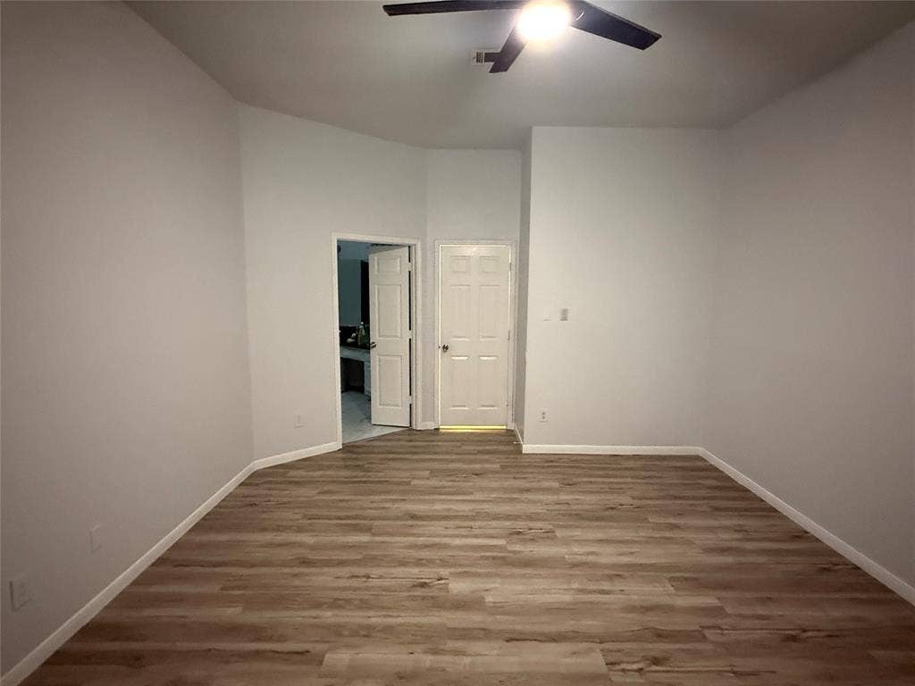 14 Heritage Way, Allen, TX 75002 Neutral-toned interior space featuring wood-finish flooring, high ceilings, and a ceiling-mounted light fixture with fan