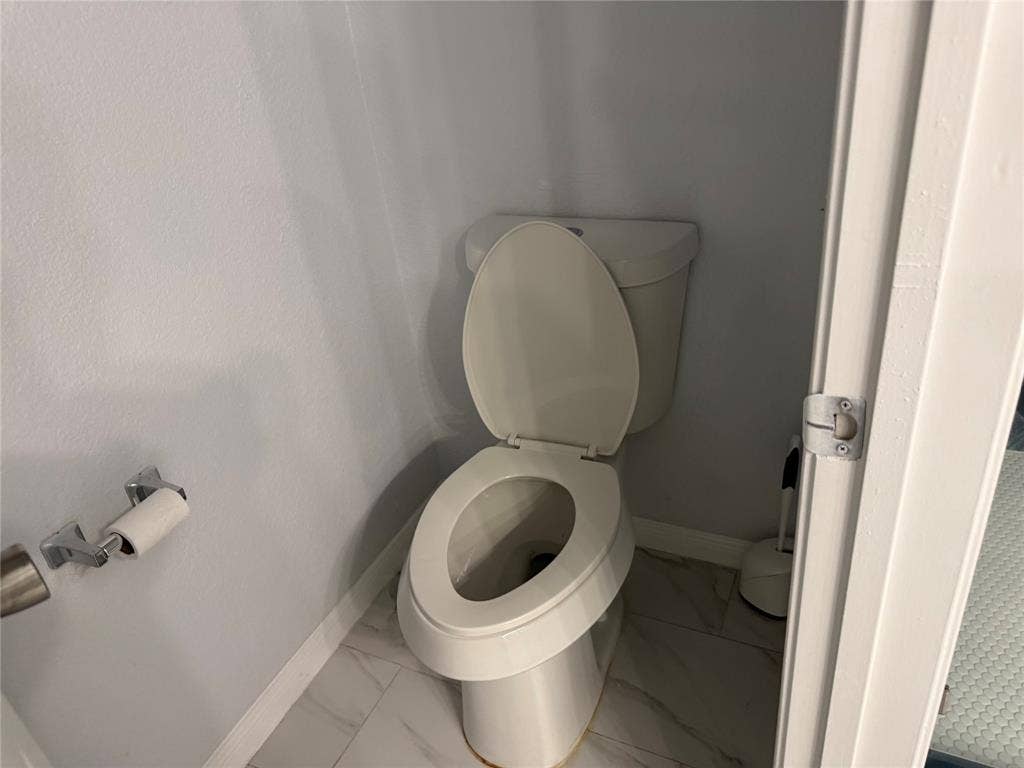 14 Heritage Way, Allen, TX 75002 Commode featuring a chrome-finished toilet paper holder and large-format tile flooring