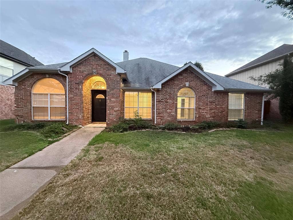 14 Heritage Way, Allen, TX 75002 Brick exterior featuring an arched entryway, multiple arched windows, and a concrete walkway
