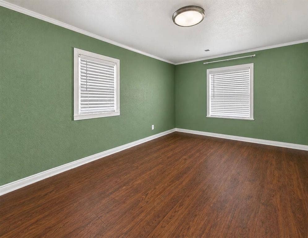 5512 Curzon Avenue, Fort Worth, TX 76107 Room featuring wood-finish flooring, two windows with horizontal blinds, and a central flush-mount light fixture