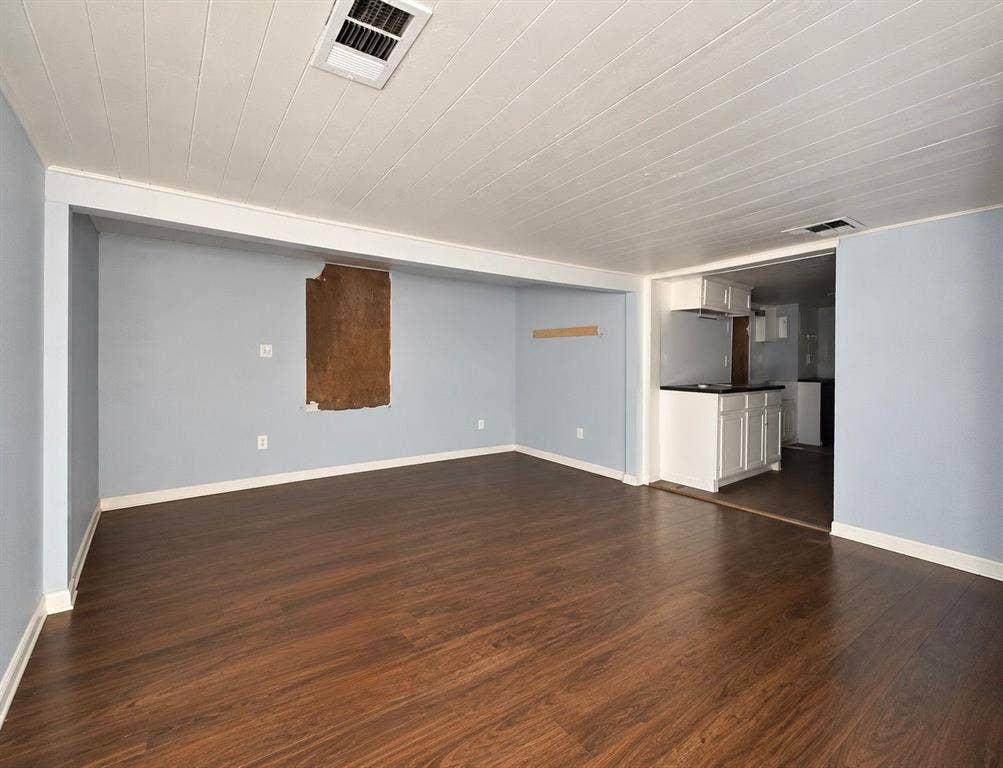 5512 Curzon Avenue, Fort Worth, TX 76107 Interior space featuring wood-finish flooring, a white paneled ceiling, and built-in white cabinetry with a dark countertop