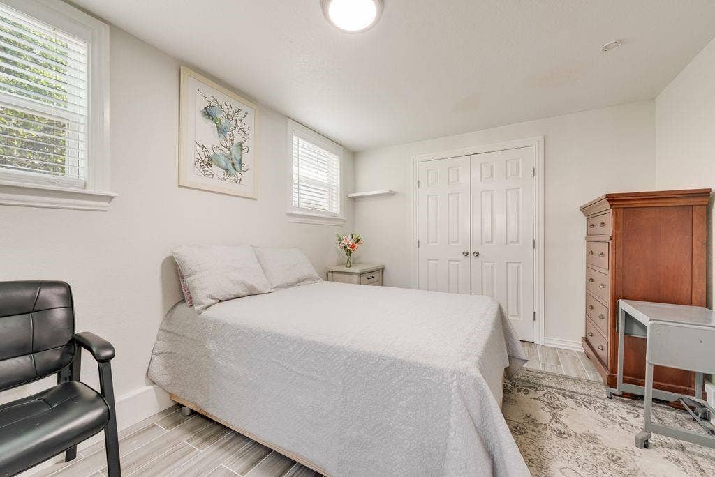 2815 Anzio Drive, Dallas, TX 75224 Neutral-toned interior featuring dual windows with horizontal blinds, wood-finish tile flooring, and a double-door closet with polished nickel hardware