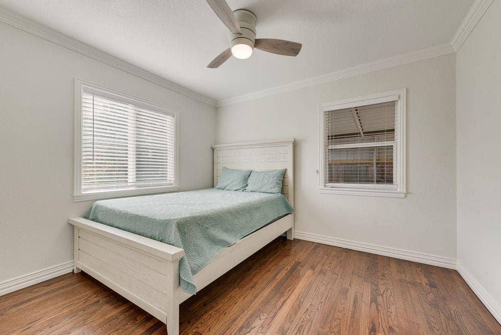 2815 Anzio Drive, Dallas, TX 75224 Wood-finish flooring, crown molding, multi-pane windows with horizontal blinds, and a central ceiling fan with integrated lighting