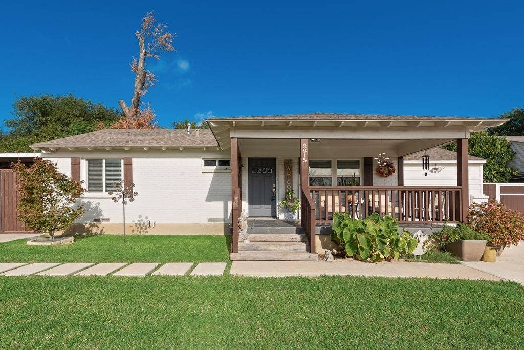 2815 Anzio Drive, Dallas, TX 75224 Single-story exterior featuring painted brick siding, a covered front porch with timber-style railings, and a concrete paver walkway