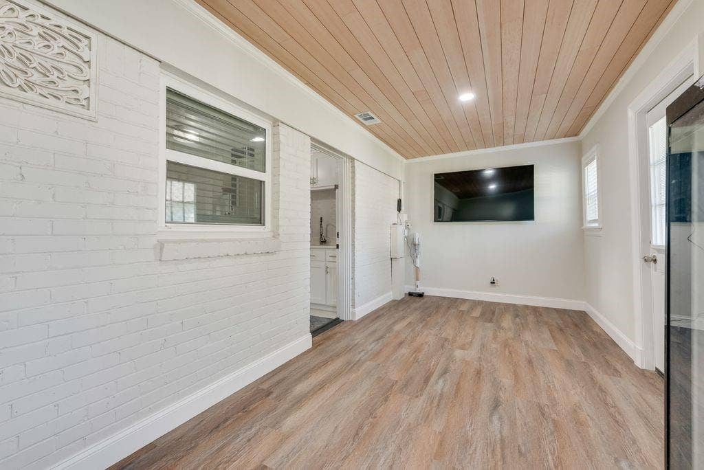2815 Anzio Drive, Dallas, TX 75224 Interior space featuring white-painted brick walls, wood-finish flooring, a wood-plank ceiling, and recessed lighting