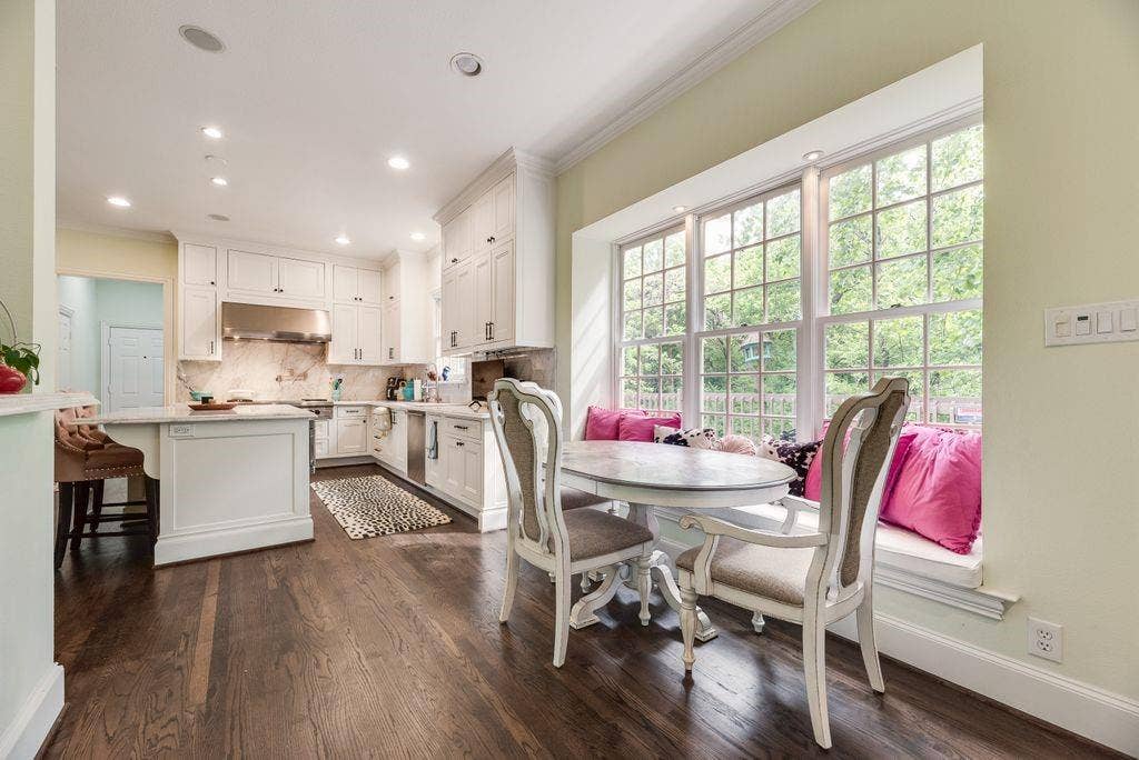 1418 Yakimo Drive, Dallas, TX 75208 Kitchen featuring white shaker-style cabinetry, a large center island, wood-finish flooring, recessed lighting, and a window-lined breakfast nook with a built-in bench