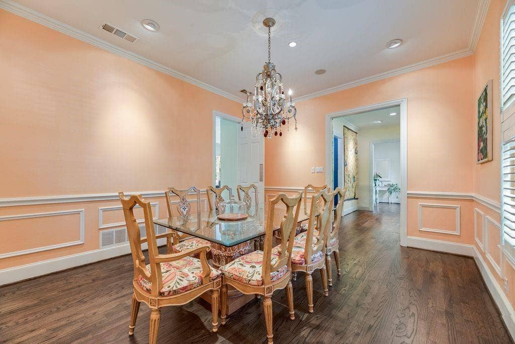 1418 Yakimo Drive, Dallas, TX 75208 Dining area featuring wood-finish flooring, decorative wall molding, crown molding, and an ornate crystal chandelier