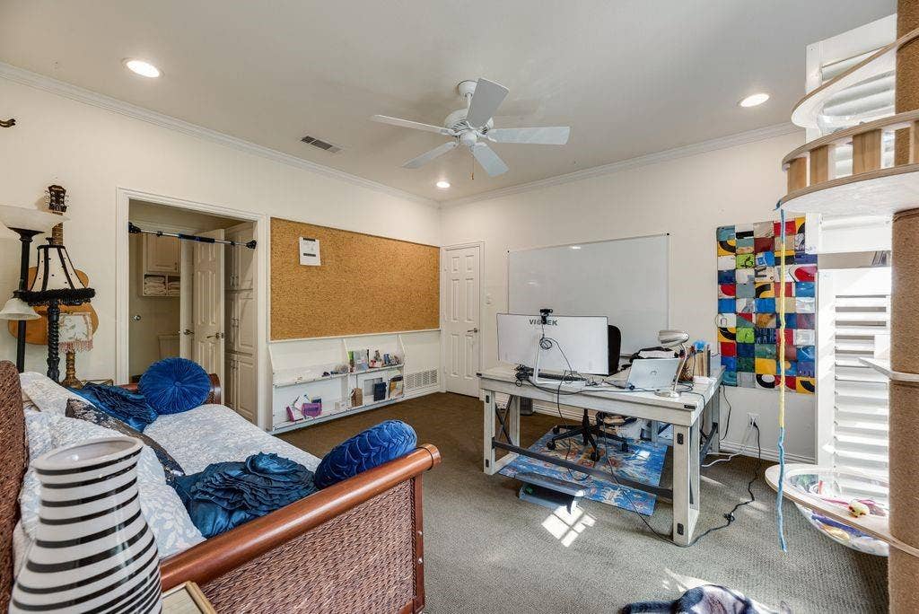 1418 Yakimo Drive, Dallas, TX 75208 Neutral-toned interior space featuring recessed lighting, a white ceiling fan, wall-to-wall carpeting, and a built-in wall-mounted cork board with integrated shelving
