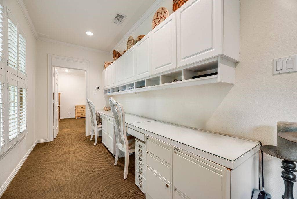 1418 Yakimo Drive, Dallas, TX 75208 Built-in white cabinetry featuring upper storage units, open shelving, and integrated desk workspace with drawers
