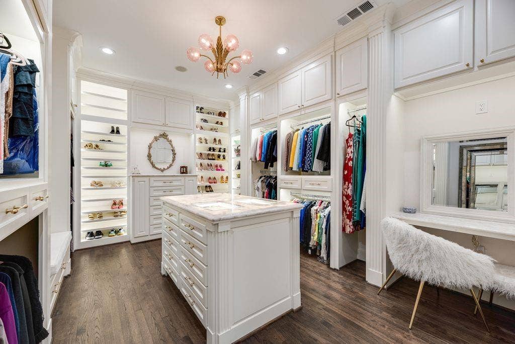1418 Yakimo Drive, Dallas, TX 75208 Custom built-in cabinetry featuring extensive shelving, central island with stone-finish countertop, recessed lighting, brass-finish chandelier, and wood-finish flooring