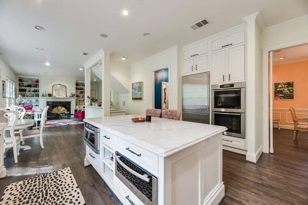 1418 Yakimo Drive, Dallas, TX 75208 Kitchen featuring a central island with a stone countertop, white custom cabinetry, built-in double wall ovens, stainless steel microwave drawer, and wood-finish flooring