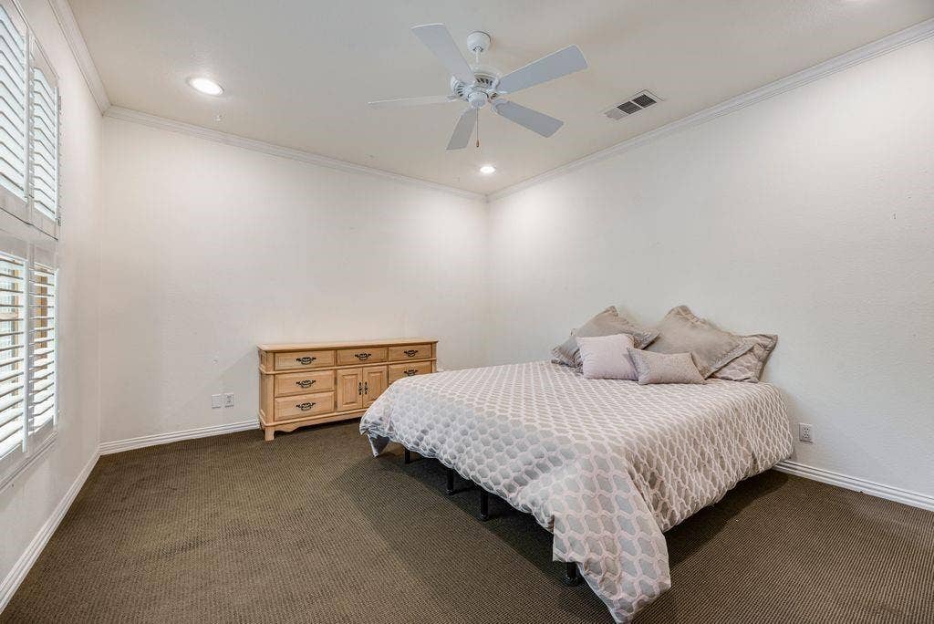 1418 Yakimo Drive, Dallas, TX 75208 Spacious interior featuring high ceilings, crown molding, recessed lighting, a white ceiling fan, and plantation shutters