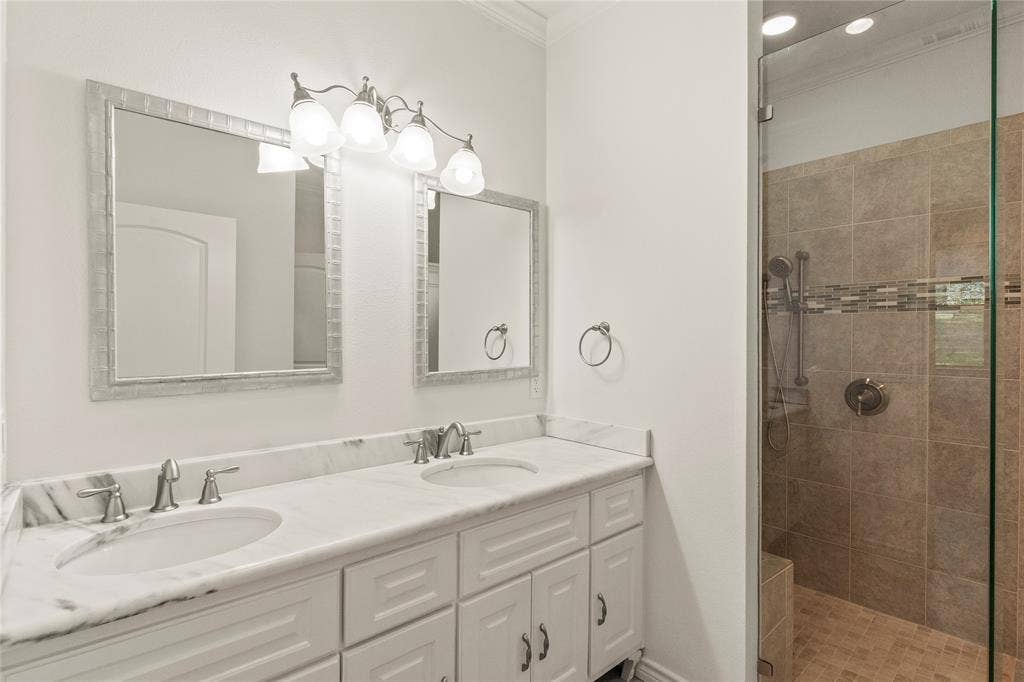 409 Oak Creek Drive, Tool, TX 75143 Primary bathroom featuring a double-sink vanity with marble-look countertops and a large walk-in tiled shower.