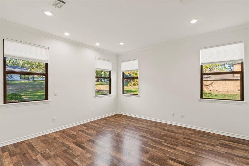 409 Oak Creek Drive, Tool, TX 75143 Primary bedroom featuring wood-look flooring, recessed lighting, and multiple windows.