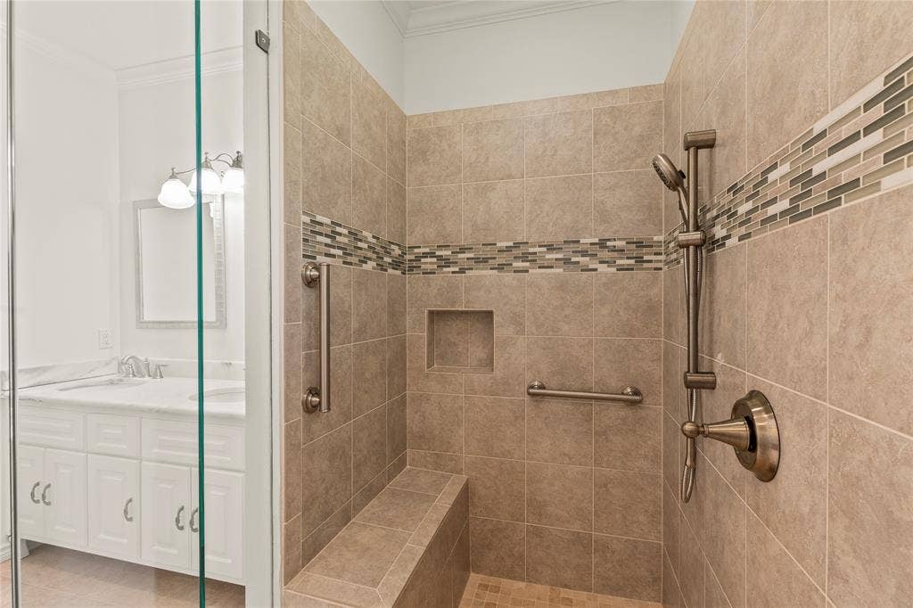 409 Oak Creek Drive, Tool, TX 75143 Primary Walk-in tiled shower featuring decorative tile accents, a built-in bench, and handheld showerhead.
