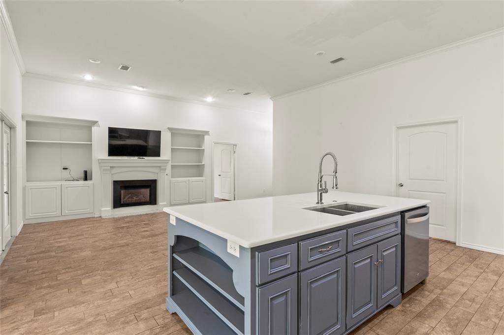 409 Oak Creek Drive, Tool, TX 75143 Open-concept kitchen overlooking the living area with a gas fireplace and custom built-in shelving.