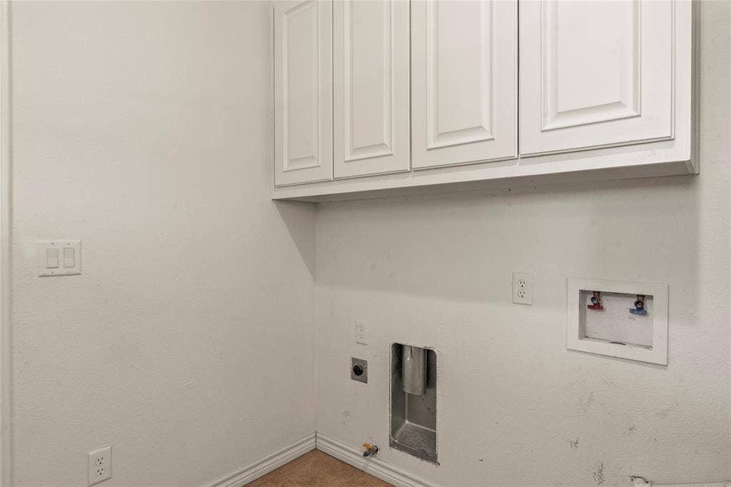 409 Oak Creek Drive, Tool, TX 75143 Laundry room with washer and dryer connections and overhead cabinetry.