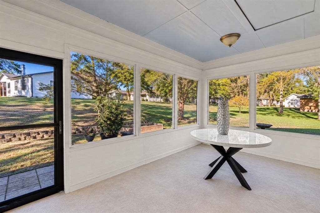 409 Oak Creek Drive, Tool, TX 75143 Screened porch with walls of windows overlooking the backyard.