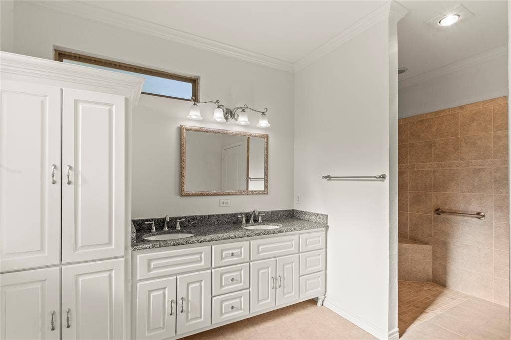 409 Oak Creek Drive, Tool, TX 75143 Ensuite bathroom two with double-sink granite vanity, generous cabinet storage, and walk-in tiled shower.