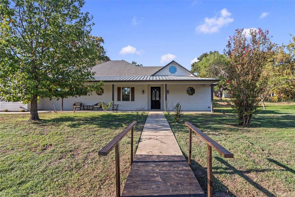 409 Oak Creek Drive, Tool, TX 75143 Welcoming front exterior with a covered front porch and mature shade trees.