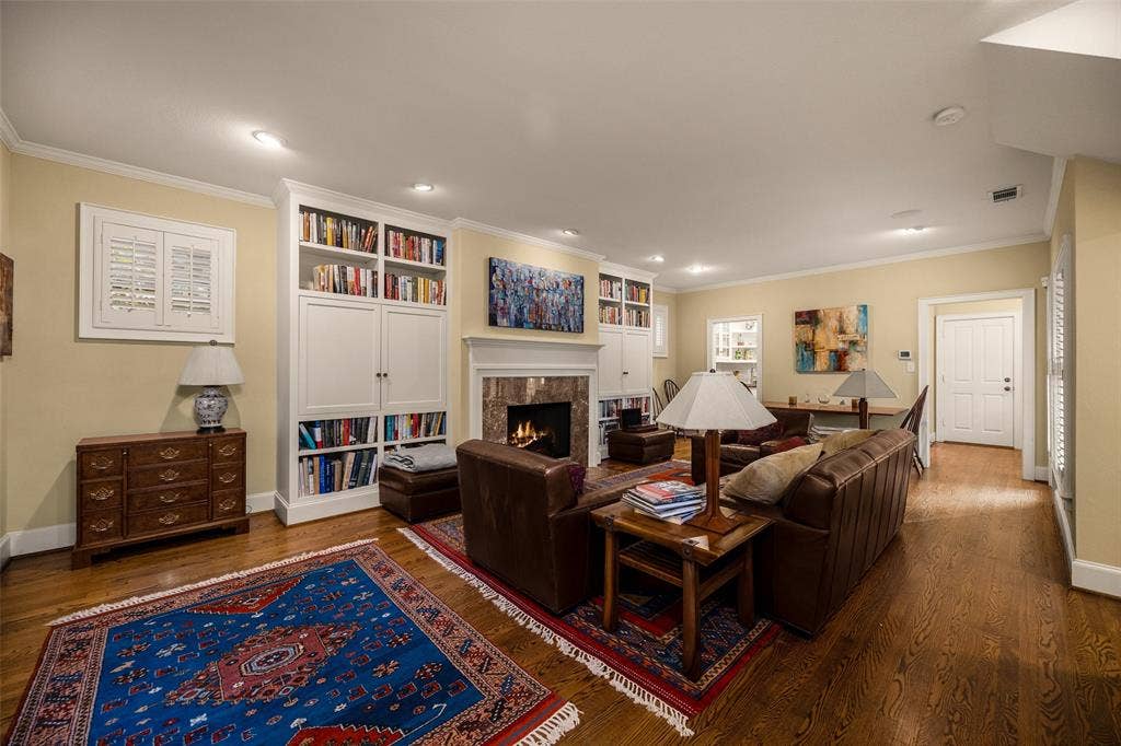 6020 Tremont Street, Dallas, TX 75214 Living area featuring hardwood flooring, recessed lighting, and a fireplace with a stone-surround mantel flanked by floor-to-ceiling custom built-in cabinetry