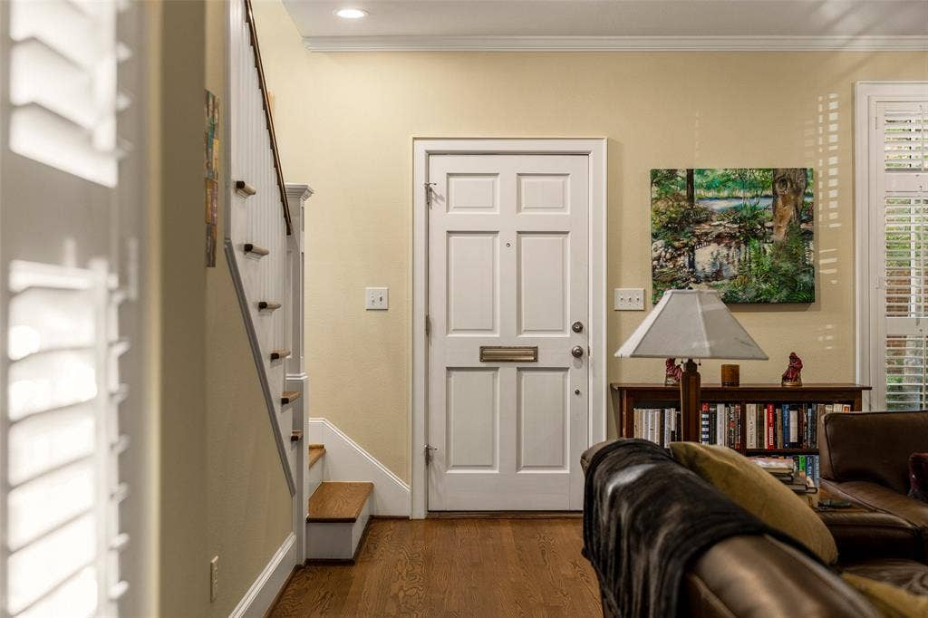 6020 Tremont Street, Dallas, TX 75214 Entryway featuring a six-panel exterior door with integrated mail slot, wood-finish flooring, staircase with white-painted balusters and wood-finish treads, and recessed ceiling lighting