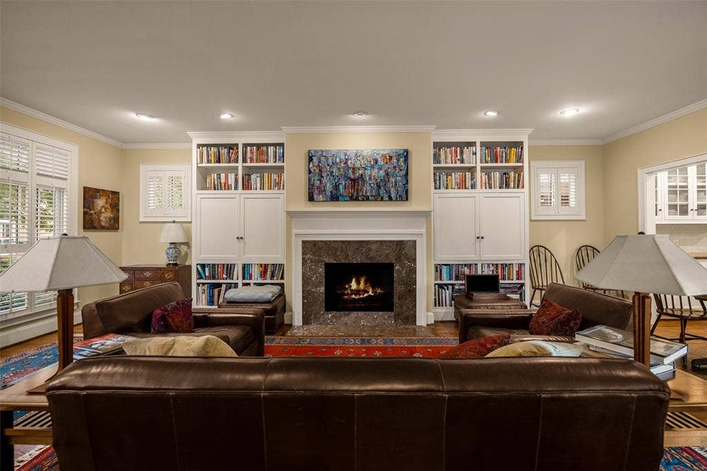 6020 Tremont Street, Dallas, TX 75214 Floor-to-ceiling built-in cabinetry, stone-surround fireplace, and window shutters