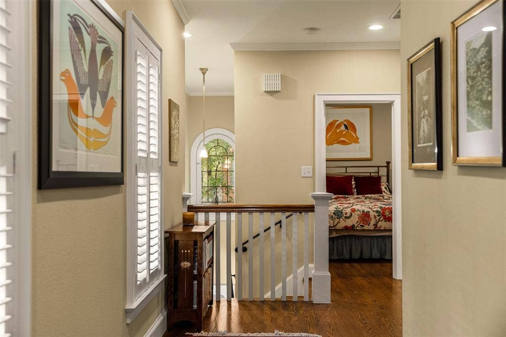 6020 Tremont Street, Dallas, TX 75214 Wood-finish flooring, arched window with multi-pane glass, white-painted wood balustrade, and plantation shutters