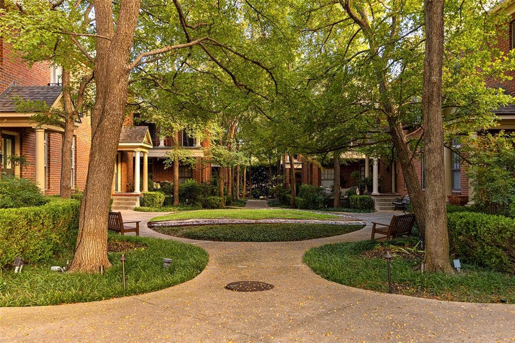 6020 Tremont Street, Dallas, TX 75214 Courtyard featuring brick exterior facades, architectural columns, paved pathways, mature canopy trees, and manicured landscaping
