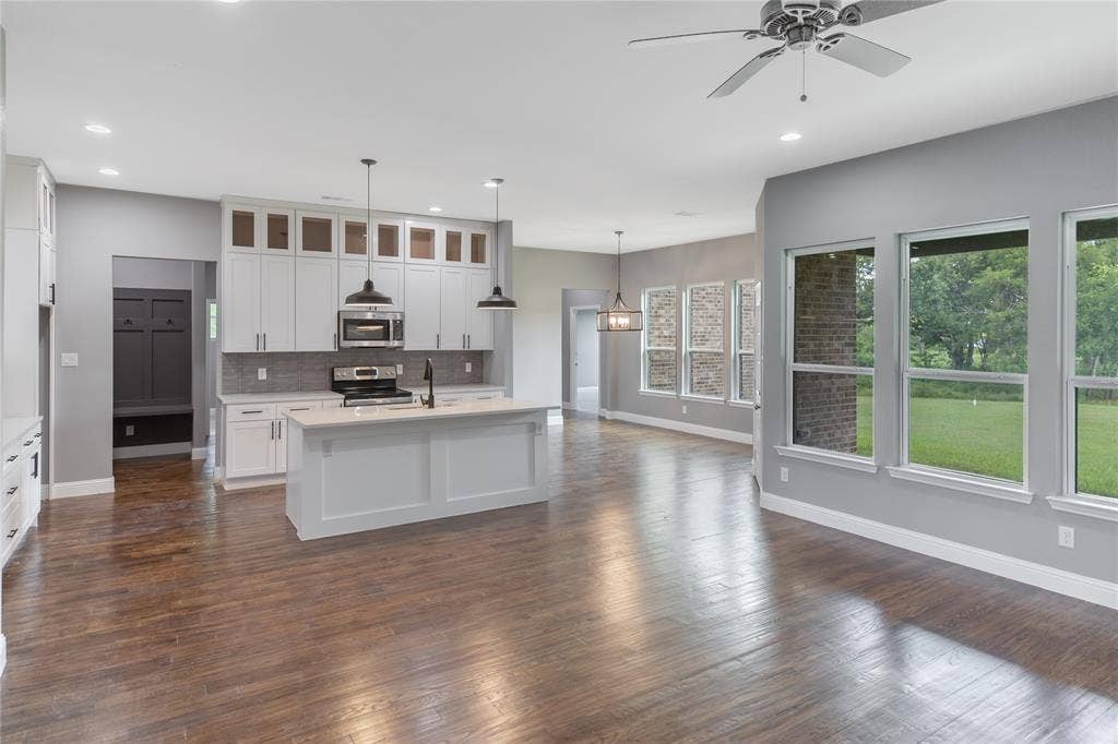 10560 Lago Vista, Quinlan, TX 75474 Kitchen featuring glass insert cabinets, tasteful backsplash, decorative light fixtures, white cabinets, and appliances with stainless steel finishes