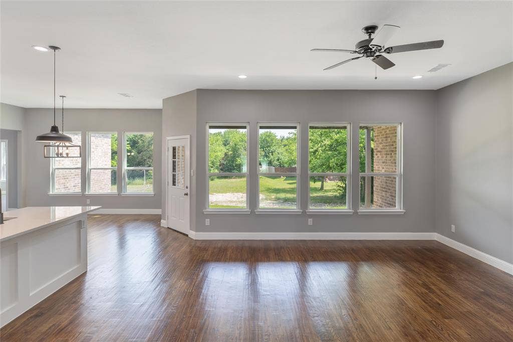 10560 Lago Vista, Quinlan, TX 75474 Unfurnished living room featuring dark wood-style floors, plenty of natural light, a ceiling fan, and recessed lighting