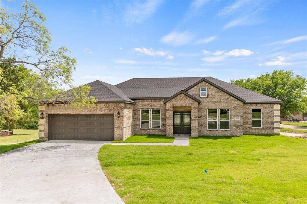 10560 Lago Vista, Quinlan, TX 75474 View of front facade with a shingled roof, a front lawn, brick siding, concrete driveway, and french doors