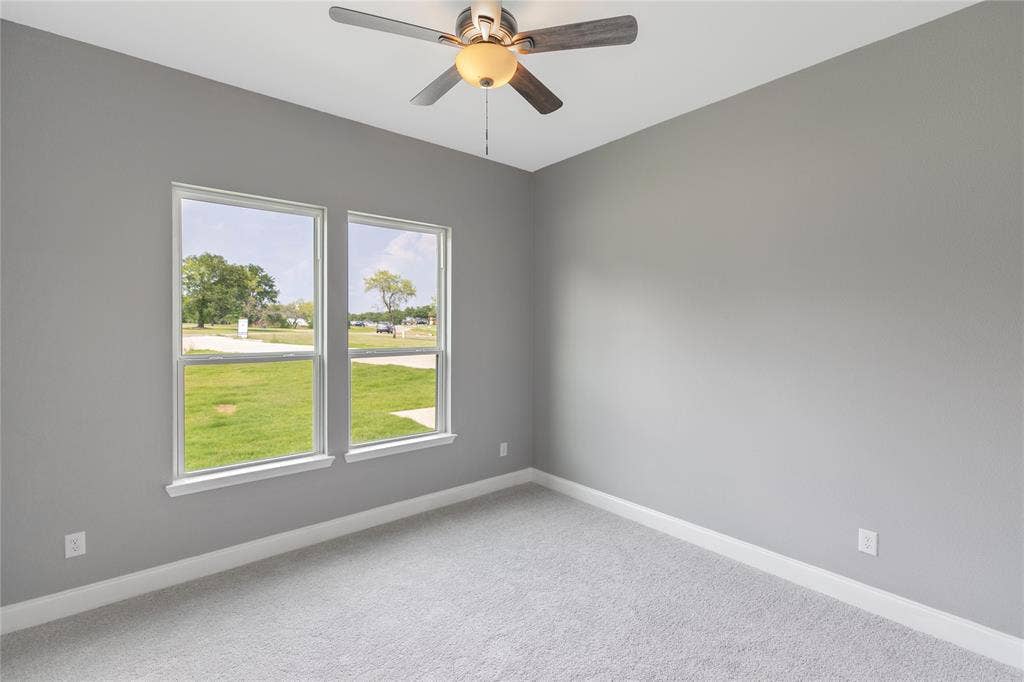 10560 Lago Vista, Quinlan, TX 75474 Carpeted empty room with baseboards and a ceiling fan